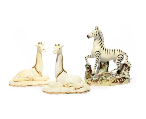 A pair of Grainger Lee (Worcester) figures of giraffes, c.1828, recumbent on rocky bases with heads erect, left in the white 