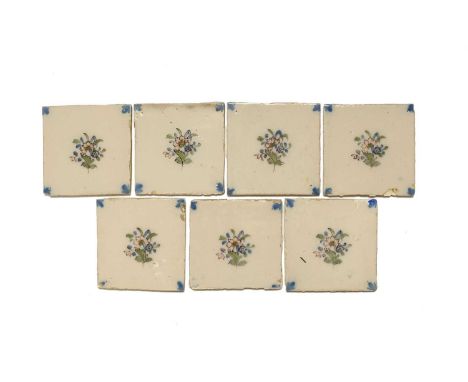 A group of seven London delftware tiles, mid 18th century, painted in polychrome enamels with a central flower spray, the cor