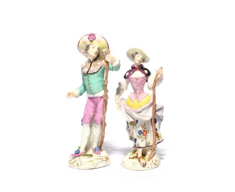 Two Meissen figures of pilgrims, mid 18th century, each wearing a short cape and a wide-brimmed hat decorated with scallop sh