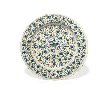 A Bristol delftware charger, c.1710-30, painted in red, green and blue with a bird in a central roundel on a ground of dense 