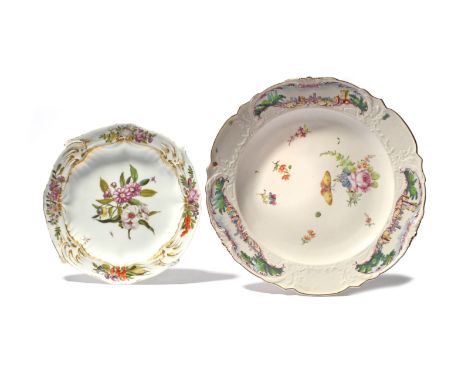 Two Chelsea plates, c.1755-60, one of Warren Hastings type, the moulded rim painted with landscape panels, the well with flow