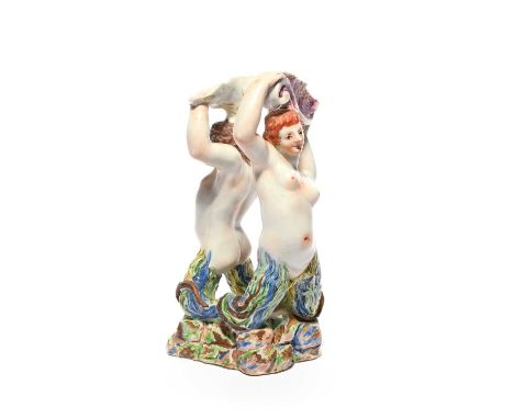 A Doccia figural sugar stand, c.1755, formed as a triton and a sea nymph raised on a rocky base and holding the edges of a sh