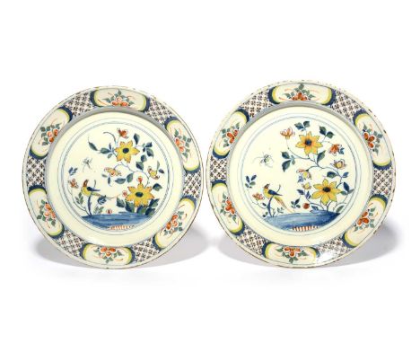 A pair of delftware chargers, c.1730-40, probably Bristol, each painted in polychrome enamels with a long-tailed bird perched