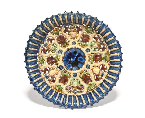 An early French Palissy style dish, c.1600, the circular dish modelled with an openwork design of six cherub masks alternatin