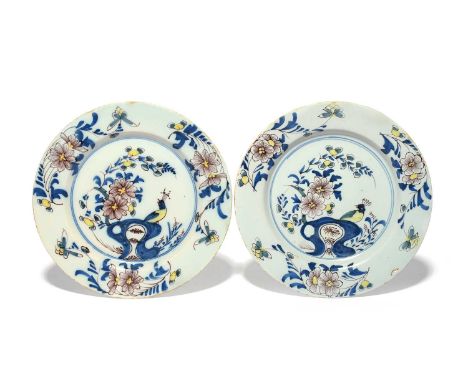A pair of Bristol delftware plates, c.1760, painted in blue, manganese and yellow with a peacock seated on holey rockwork bef