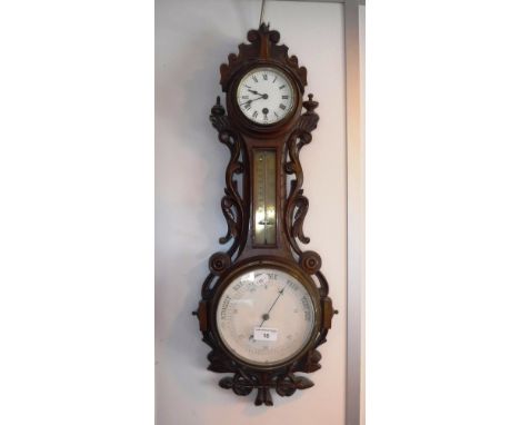 A VICTORIAN CARVED OAK BAROMETER with clock above and central thermometer 