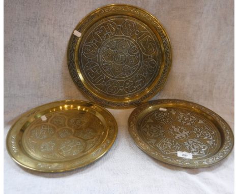 THREE ISLAMIC SILVER-INLAID COPPER DISHES, decorated with calligraphy and foliate motifs, late 19th/early 20th century