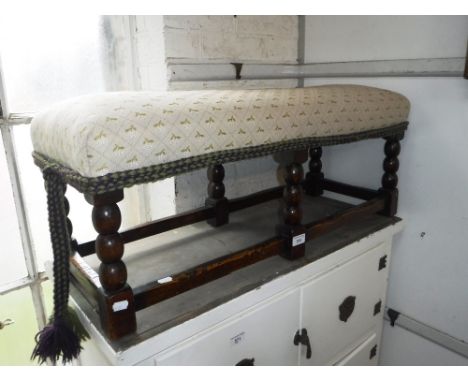 A 1920'S OAK STOOL, with upholstered top and bobbin-turned legs