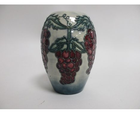 A contemporary Moorcroft pottery vase,  a trial piece with tube lined decoration of red grapes upon a light blue ground, sign