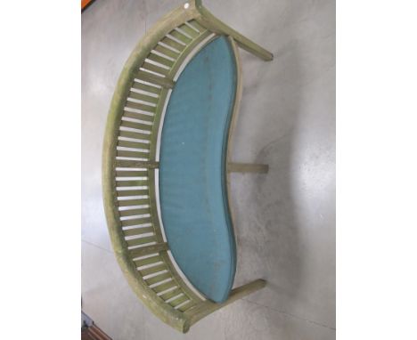 A contemporary hardwood curved back garden bench,  with a green loose cushion, 160cm x 60cm x 84cm