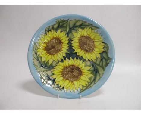 A contemporary Moorcroft pottery charger, of circular form, in the 'Sunflower' pattern designed by Sally Tuffin, 'WM' monogra