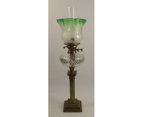 A 19th century brass oil lamp, raised on a Corinthian column with a stepped base, having a green overlay bowl and tinted shad