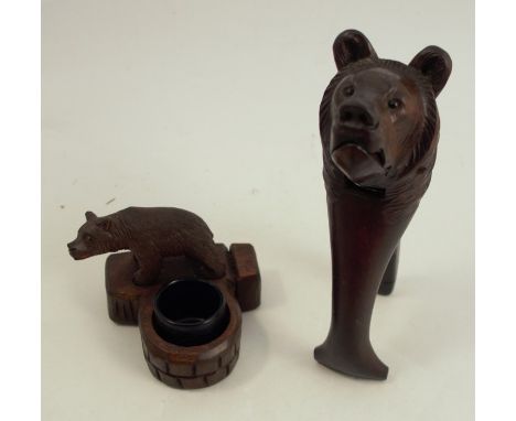 A pair of Black Forest carved nutcrackers, carved with a bear's head, together with a Black Forest carved inkwell, mounted wi