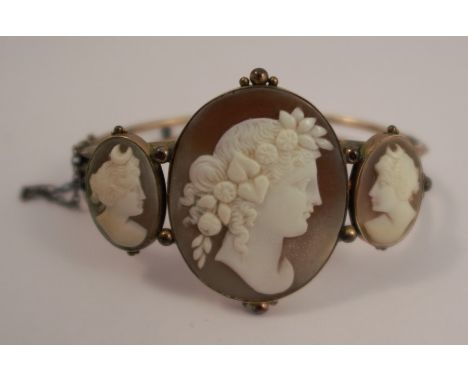 A cameo set hinged bangle, the three graduated cameos carved as classical female profiles, 18.7g grossCondition Report:  The 