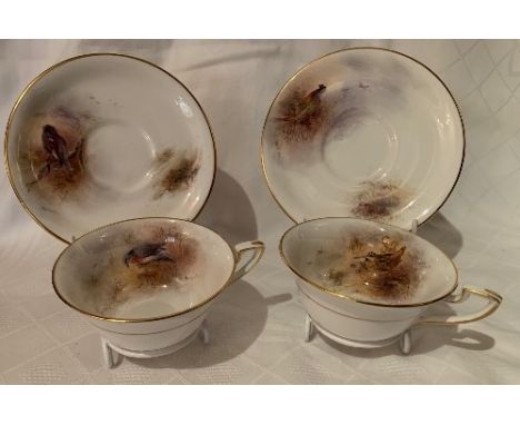 A pair of Royal Worcester cups and saucers, decorated with blackcock, wood pigeon, pheasants and woodcock by James Stinton,&n