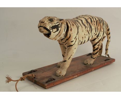 A Victorian automaton pull along tiger, with nodding head and moving jaw, on a pine base, with metal spiked wheels, length 14