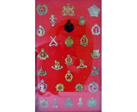 28 military cap badges including Military Foot Police, Army Cyclist Corp and Army Ordnance Corp, framed and glazed