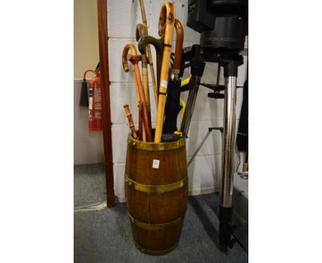 A brass bound barrel shaped stick stand and contents.