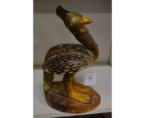 A carved and painted wood model of a bird.
