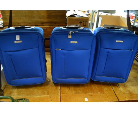 A set of three small light blue suitcases (unused).