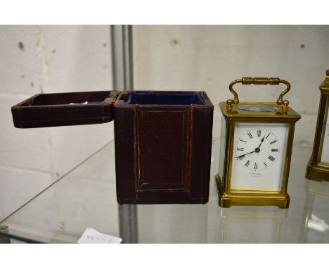 A brass carriage clock, the white enamel dial signed W Lockwood, complete with leather travelling case.