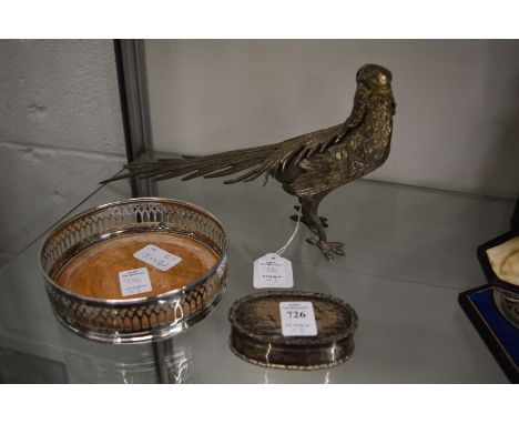 A silver pill box, plated bottle coaster and a plated model of a pheasant.