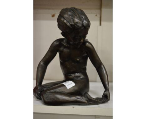 A filled bronze model of a seated female.