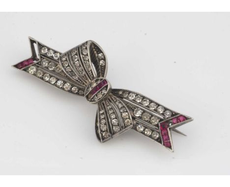 A continental white metal and paste set bow brooch,  centred with a panel of red stones, surrounded by white stones, 5 cm by 