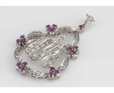 A white gold diamond and ruby openwork pendant brooch, with Arabic script surrounded by a pear shaped scroll bezel of channel