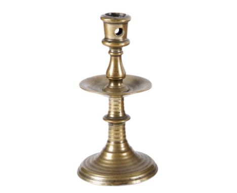 A FLEMISH 'HEEMSKIRK' BRASS CANDLESTICK16th Century 
With pierced candle holder above a baluster knopped upper stem, drip-pan