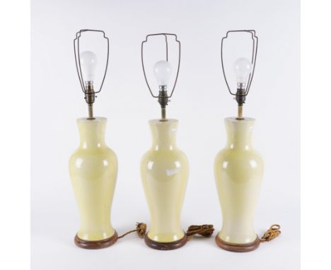 THREE YELLOW CRACKLE GLAZE CERAMIC TABLE LAMPS (3)Second half 20th Century 
Of baluster form, 40cm high (excluding light fitm