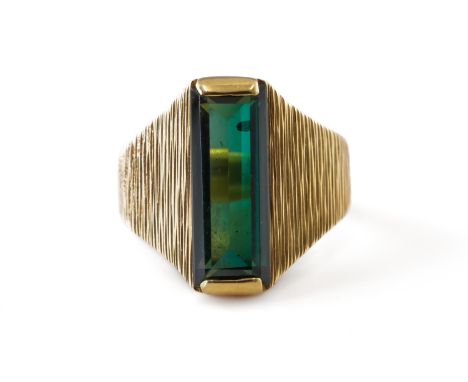 A GOLD AND GREEN TOURMALINE SINGLE STONE RINGMounted with a rectangular cut green tourmaline between bark textured tapered sh