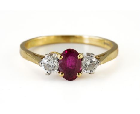 A RUBY AND DIAMOND RING (4)With a central oval cut ruby measuring 6.03mm x 3.8mm, flanked on either side by a round brilliant