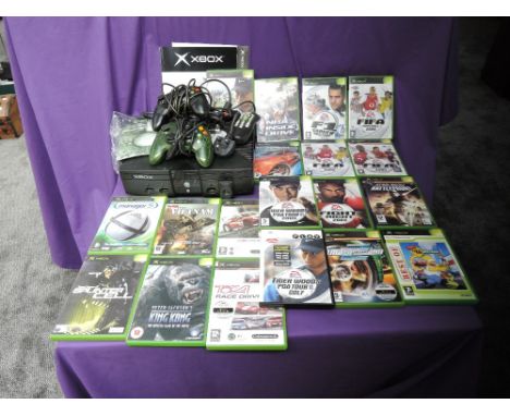 A Microsoft Xbox console with two controllers, power cable, remote control and instruction booklet along with 21 games, Tiger