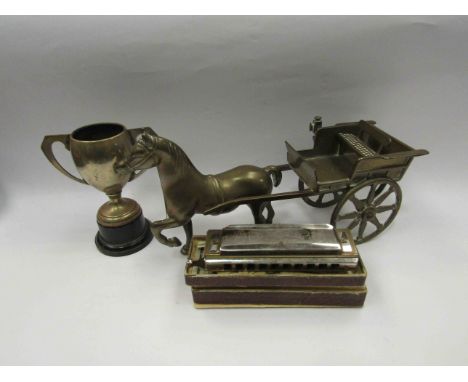 A brass model of a horse and cart, silver plated trophy and a Hohner harmonica