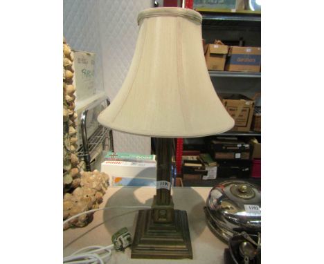 A brass column form table lamp base with mask detail    