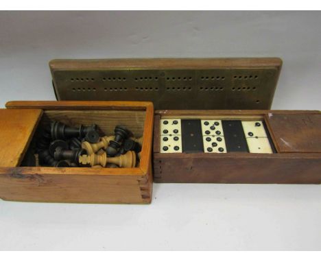 A boxed set of dominoes, boxed chess pieces and a cribbage board