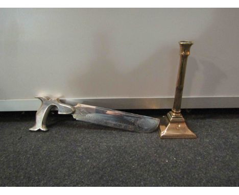 A plated knife in the form of a saw and a copper candlestick