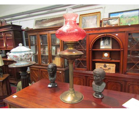 A pedestal brass and cranberry glass oil lamp, 69cm tall