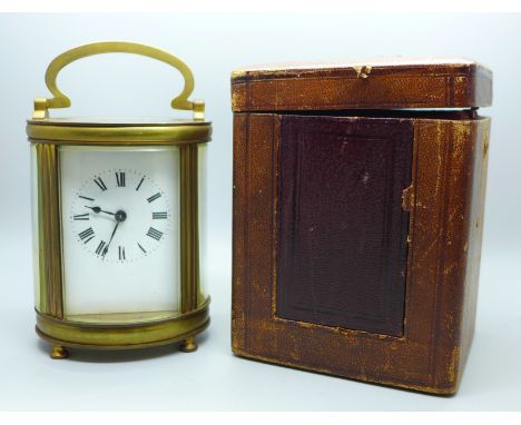 A French carriage clock, oval case with travel case and key 