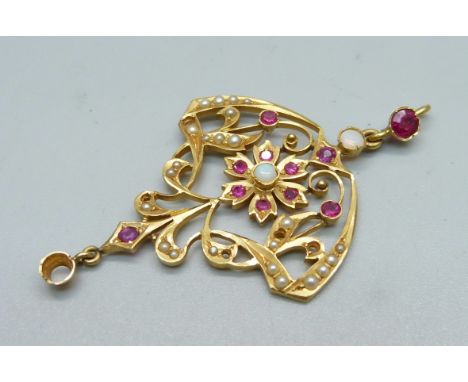 An Art Nouveau style yellow metal pendant set with opal, ruby and seed pearls, five seed pearls and one opal missing, tests a