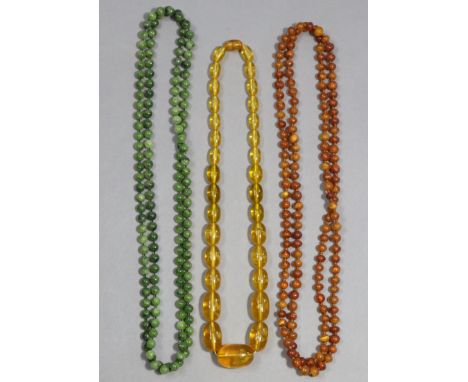 A butterscotch amber necklace, 23” long; together with an amber necklace, 48” long; &amp; a jade necklace, 51” long.