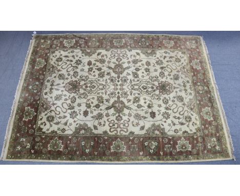 An Indian small carpet of cream ground &amp; with all-over repeating multi-coloured geometric design to centre within a wide 