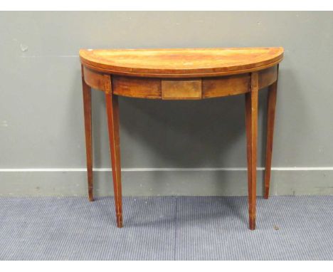 A George III style mahogany and thuya banded demi-lune games table, late 20th century, the inlaid fold-over top enclosing a g