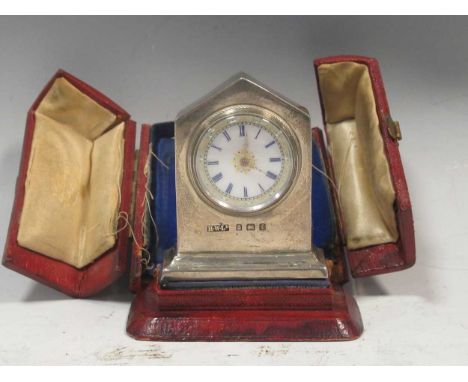 A silver fronted dressing table clock by Henry Williamson Ltd., Birmingham 1905, in a red Morocco leather case