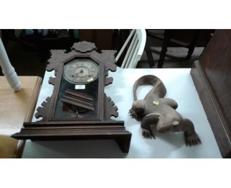 An early 20th Century oak cased two hole mantel clock and a carved wooden lizard ornament