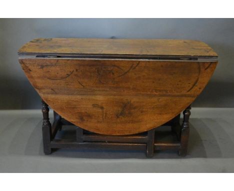 An 18th Century Oak Oval Gate Legged Dining Table, with turned legs and stretchers, 134cm by 117cm 