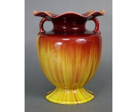 A Linthorpe pottery baluster vase with loop handles, wide foliate rim, &amp; all-over flambé glaze, on pedestal foot; 8½” hig