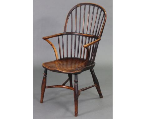 A yew &amp; elm Windsor elbow chair with a low stick-back, curved arms &amp; hard seat on baluster turned splay legs, joined 