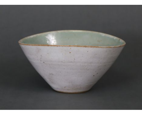 DAME LUCIE RIE &amp; HANS COPER, A STUDIO POTTERY SMALL BOWL, of slightly oval conical form with speckled oatmeal exterior gl